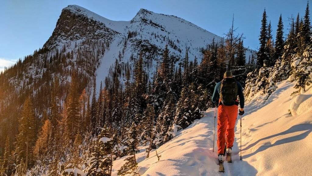 A photo of a man skinning uphill in the mountains on a well-used skin track