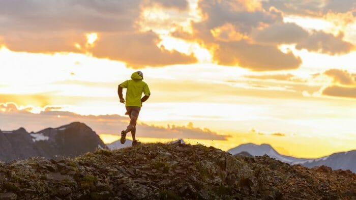 A photo of a man mountain running on a ridge line